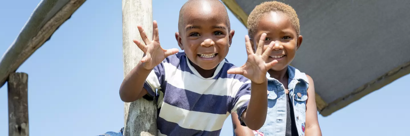 Two boys at Soyisele daycare in South Africa playing on a climbing set