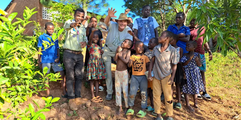 Ein Freiwilliger aus Deutschland bei einer Baumpflanzaktion mit Schülern in Malawi
