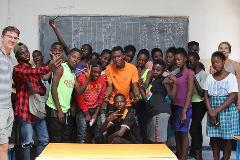 Schülergruppe im Klassenzimmer mit zwei Volunteers