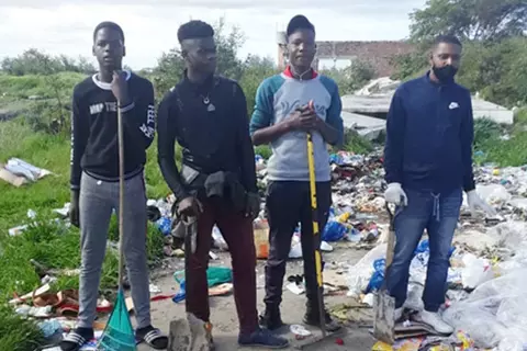 Vier Jugendliche räumen Müll weg