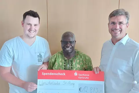 Father John Moyo receives a donation from the catholic youth organization KJG