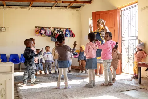A teacher singing with the children at a daycare center in Eastern Cape, South Africa