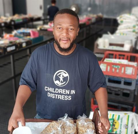A staff member of the NGO Children in Distress carrying food donations