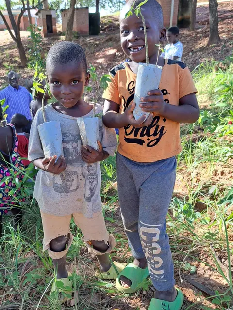 Zwei Kinder bei einer Baumpflanzaktion an einer Grundschule in Malawi