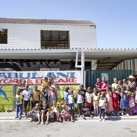 Kinder und Erzieherinnen vor dem Jabulani Day Care Center in Südafrika