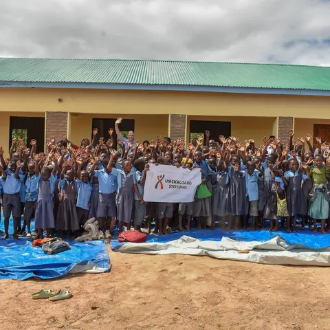 Schulkinder vor den neuen Schulgebaeuden der Primarschule in Kameme, Distrikt Chitipa, in Malawi