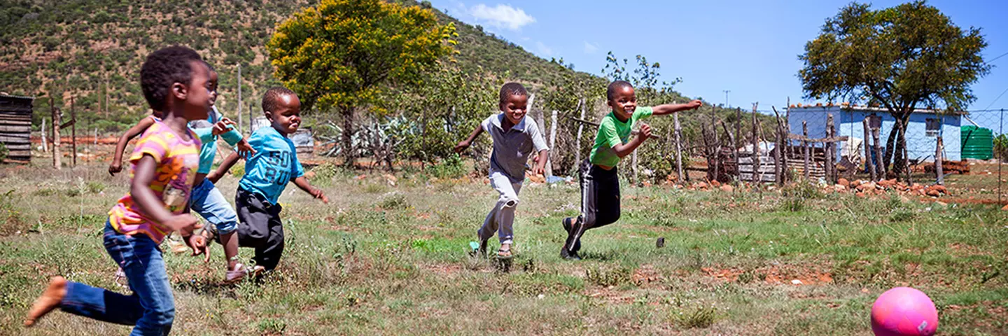 Kinder mit Ball auf einer Wiese