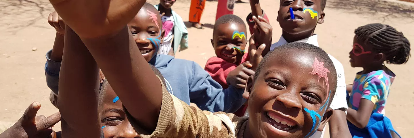 A group of children with painted faces, laughing