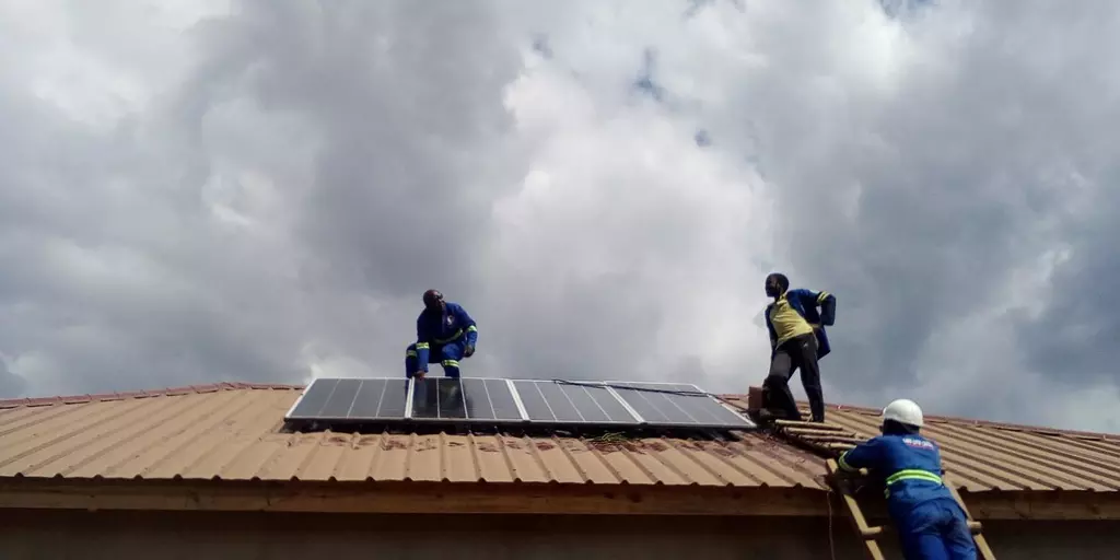 Arbeiter installieren eine Solaranlage auf einer Berufsschule in Malawi