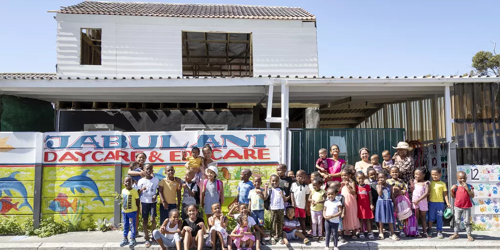 Kinder und Erzieherinnen vor dem Jabulani Day Care Center in Südafrika
