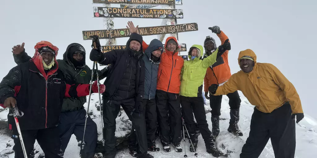Four mountaineers from Karlsruhe with their mountain guides at the summit of Kilimanjaro