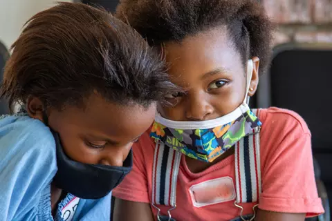Zwei kleine Kinder mit Maske