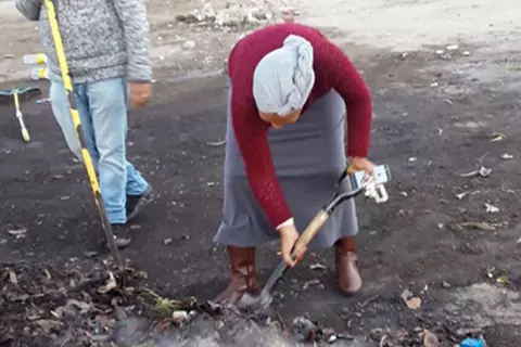 Zwei Personen räumen Müll weg