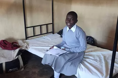 A student sits on one of the new beds at St. Ignatius boarding school in Nthalire.