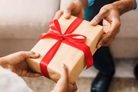 Eine Frau überreicht einem Mann ein Geschenk