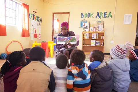 Eine Erzieherin in einer Kita der Samara-Stiftung liest den Kindern ein Buch vor