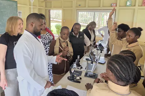 An der St. Francis-and-Clare-Schule in Sambia erklärt ein Chemielehrer den Schüler*innen die Funktionsweise eines Elektronenmikroskops.