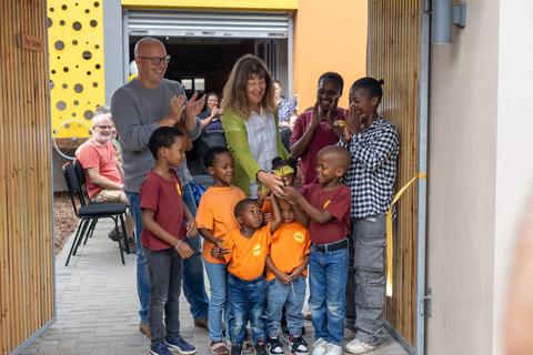 Bei der Einweihung der Montessori-Kita im Walmer Township durchschneiden Kinder das Band