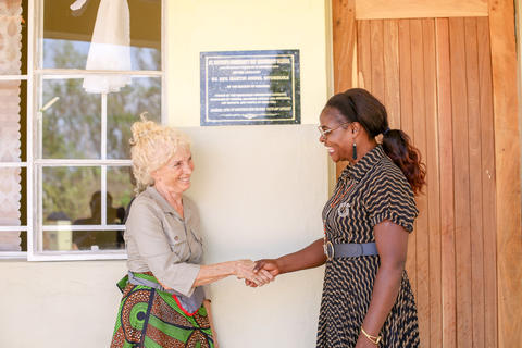 Violetta Abate und Schulleiterin Flora Chunda vor dem Verwaltungsgebäude der Schule