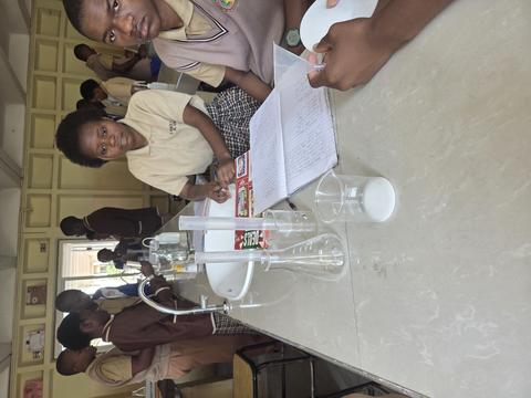 Schülerinnen und Schüler der St. Francis-and-Clare-Schule in Sambia im Chemie-Labor bei einem Experiment.