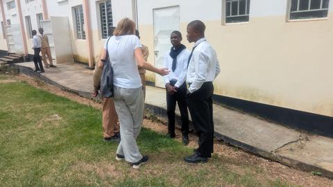 Eine Besucherin aus Deutschland unterhält sich mit Schülerinnen und Schüler der Ekuphumleni-Sekundarschule in Lusaka, Sambia.