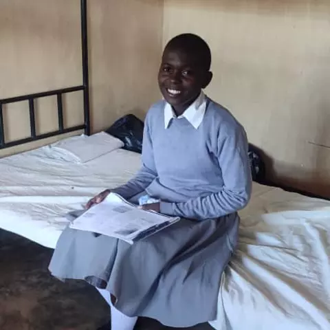 A student sits on one of the new beds at St. Ignatius boarding school in Nthalire.