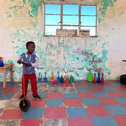 Boy with a scooter at Sizamile Educare creche