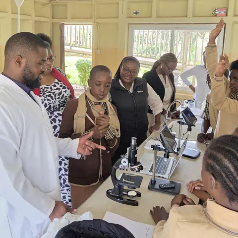 An der St. Francis-and-Clare-Schule in Sambia erklärt ein Chemielehrer den Schüler*innen die Funktionsweise eines Elektronenmikroskops.